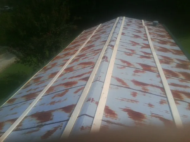 Rusted metal roof panels with new wood purlins before replacement — Storm Damage Roof Repair in Fruita by Roofing Brothers